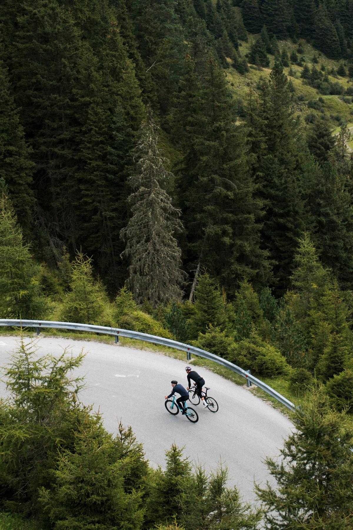 two men cycling on an empty road