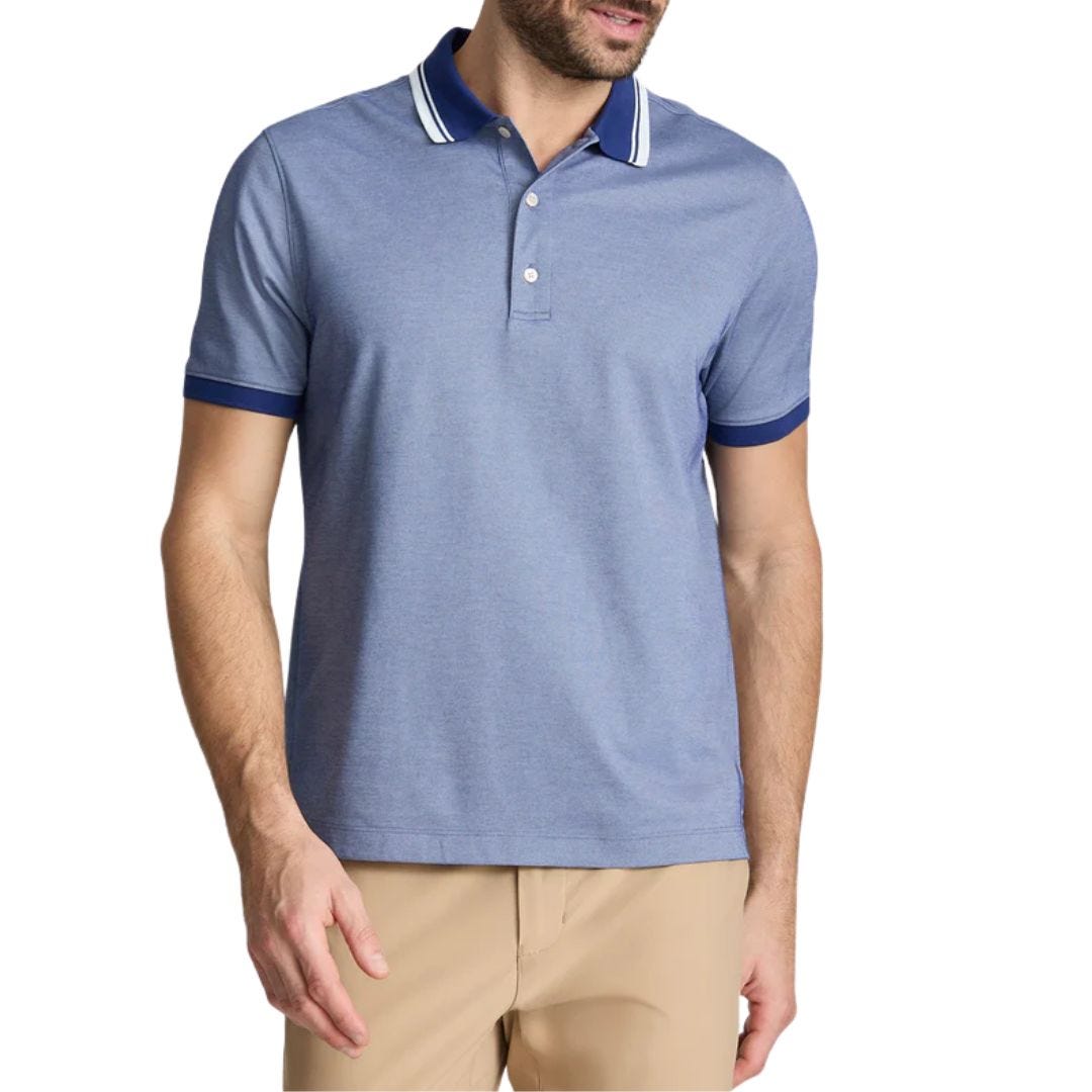 stylish man wearing a light blue tipped polo shirt and tan pants