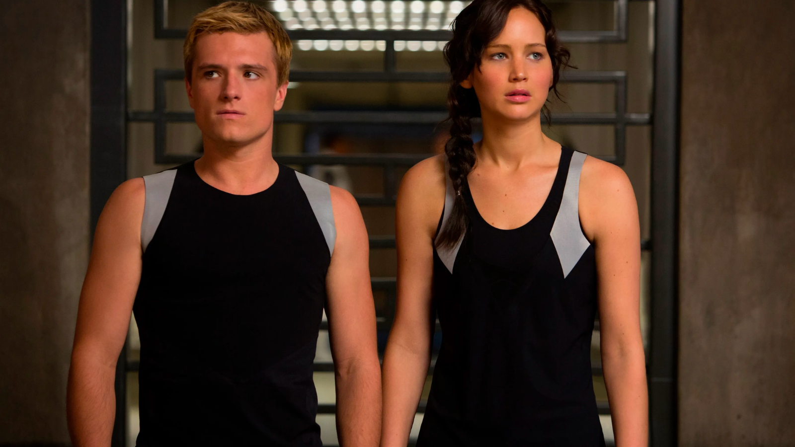 Peeta and Katniss standing side by side in The Hunger Games