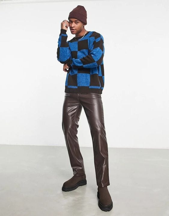 man wearing brown leather pants with blue and brown checkered sweater