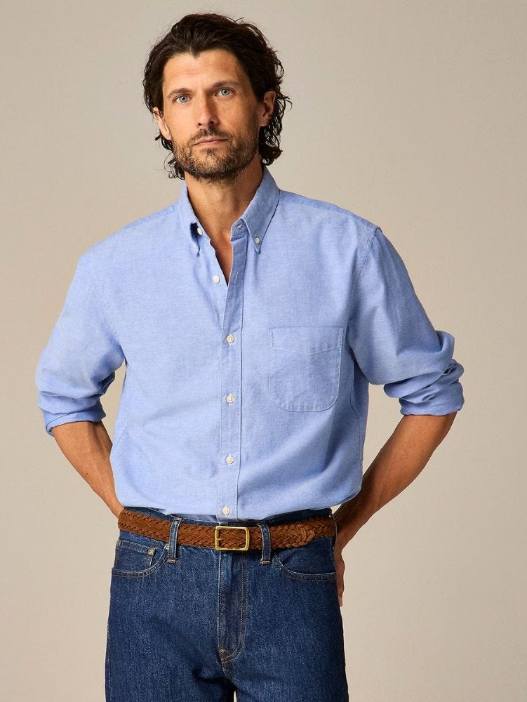 man from the waist up wearing dark jeans, a brown belt, and a blue Oxford shirt