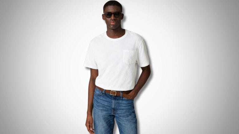 stylish man wearing a white pocket t-shirt, jeans, a leather belt and black sunglasses