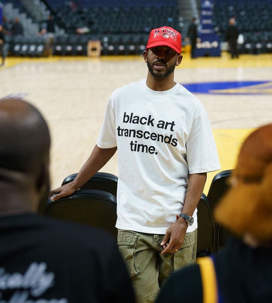 Chris Paul wearing t-shirt that reads: black art transcends time