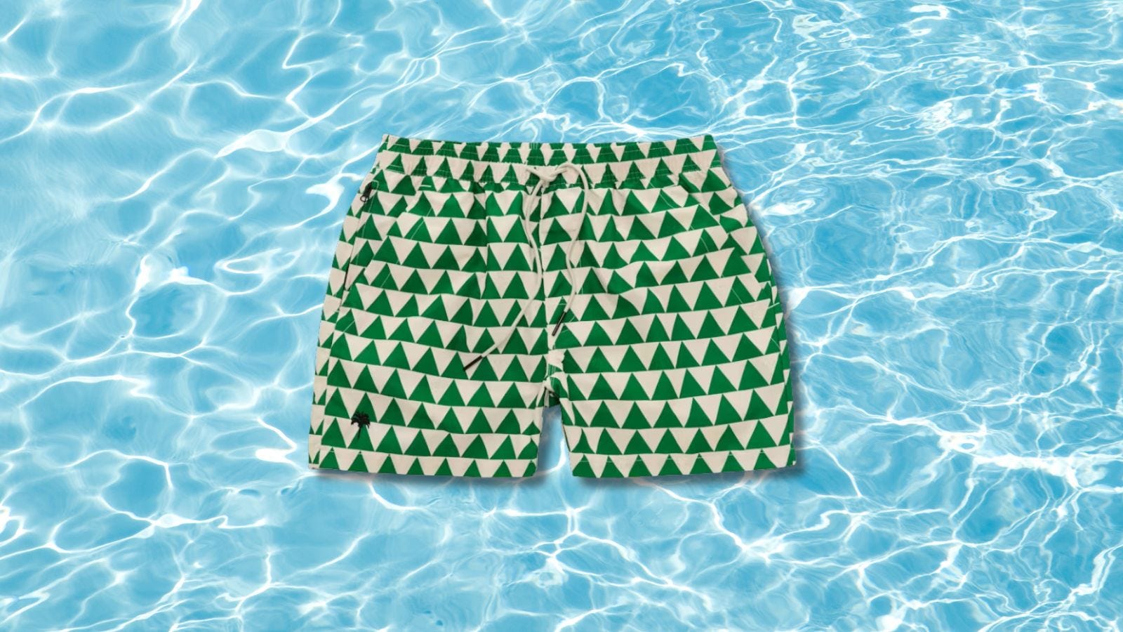 image of green and white men's swim trunks set against a pool water background