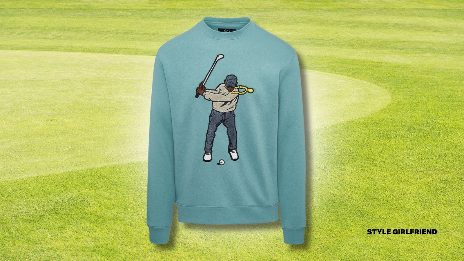 green sweatshirt with embroidery of man swinging golf club on front, set against a golf green background