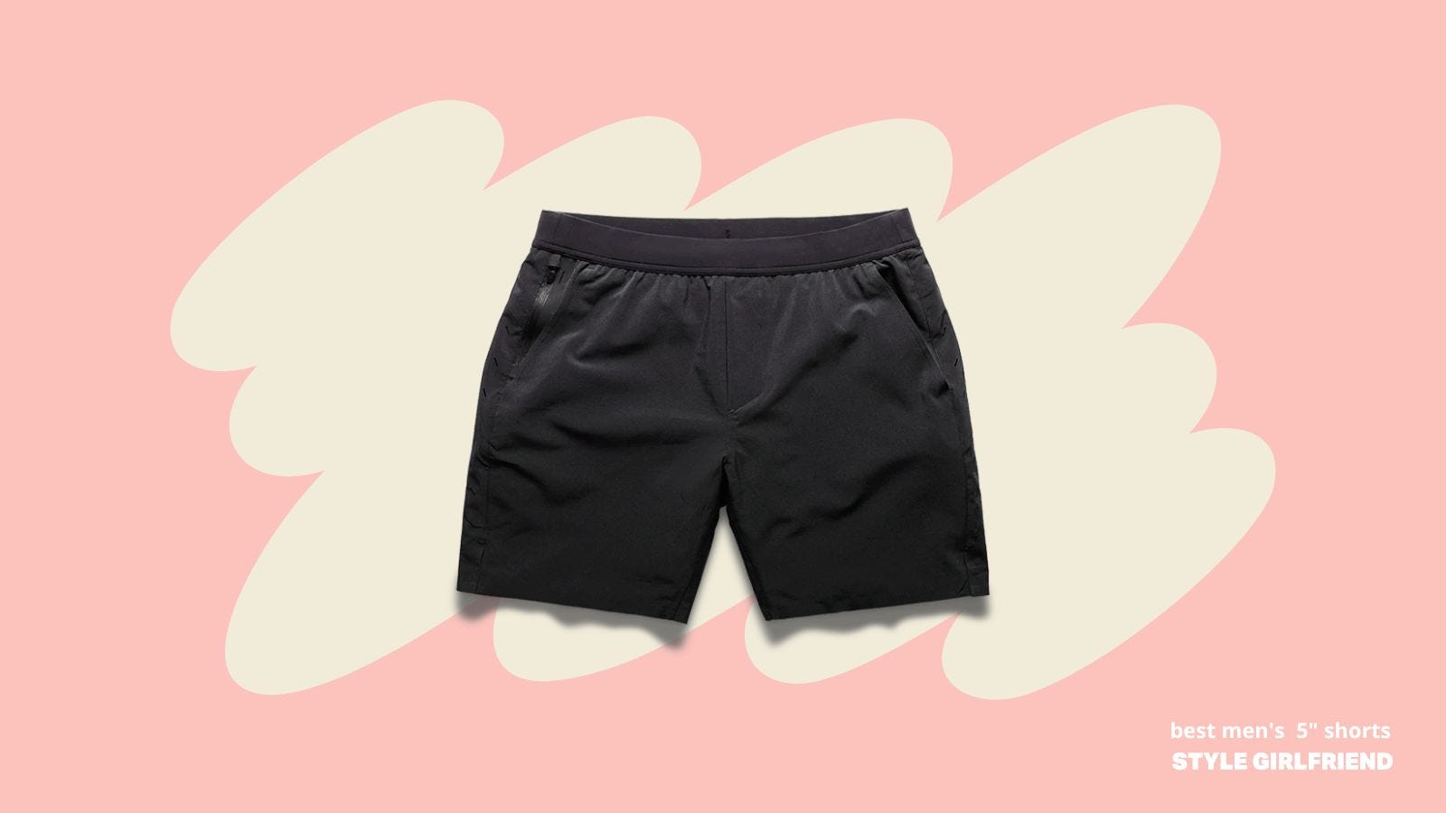 flatlay image of black technical shorts against a pink background