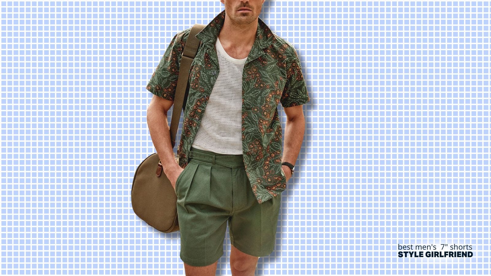 torso of man wearing a sophisticated green patterned short sleeve shirt over a white shirt with green pleated shorts. a weekender bag is slung over his shoulder