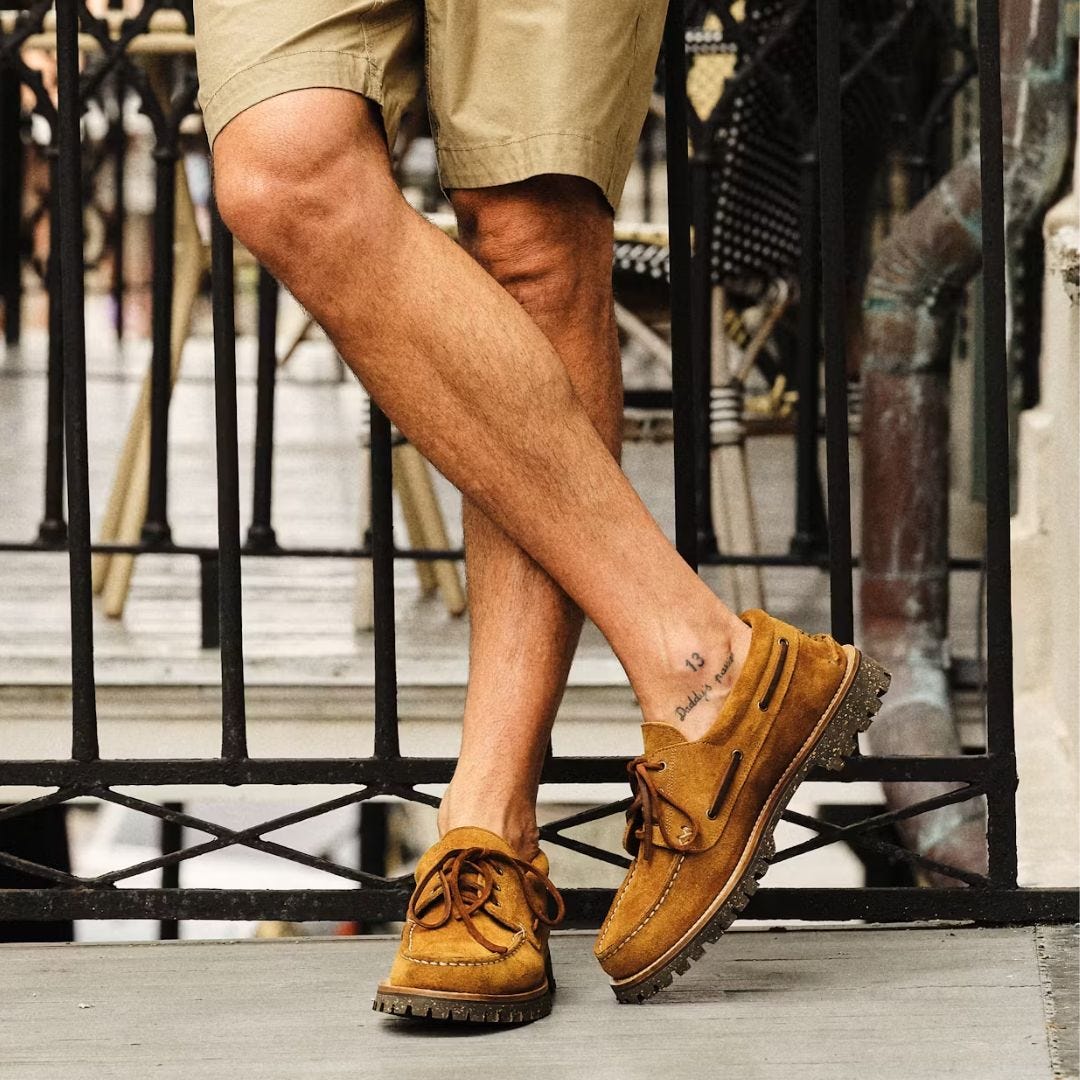 Image of a man wearing shorts and suede boat shoes from the knees down
