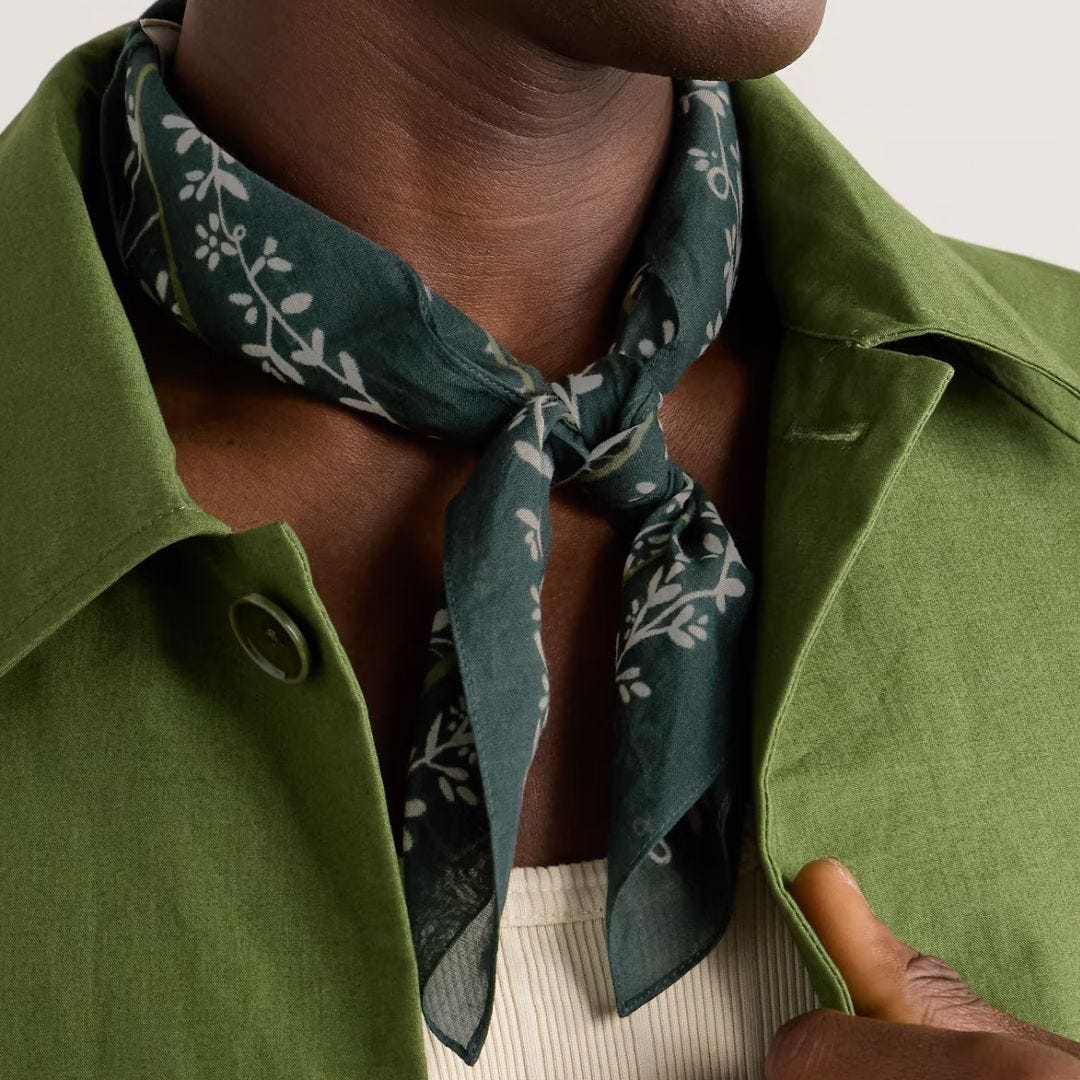 close-up of man wearing a green patterned bandana tied around his neck