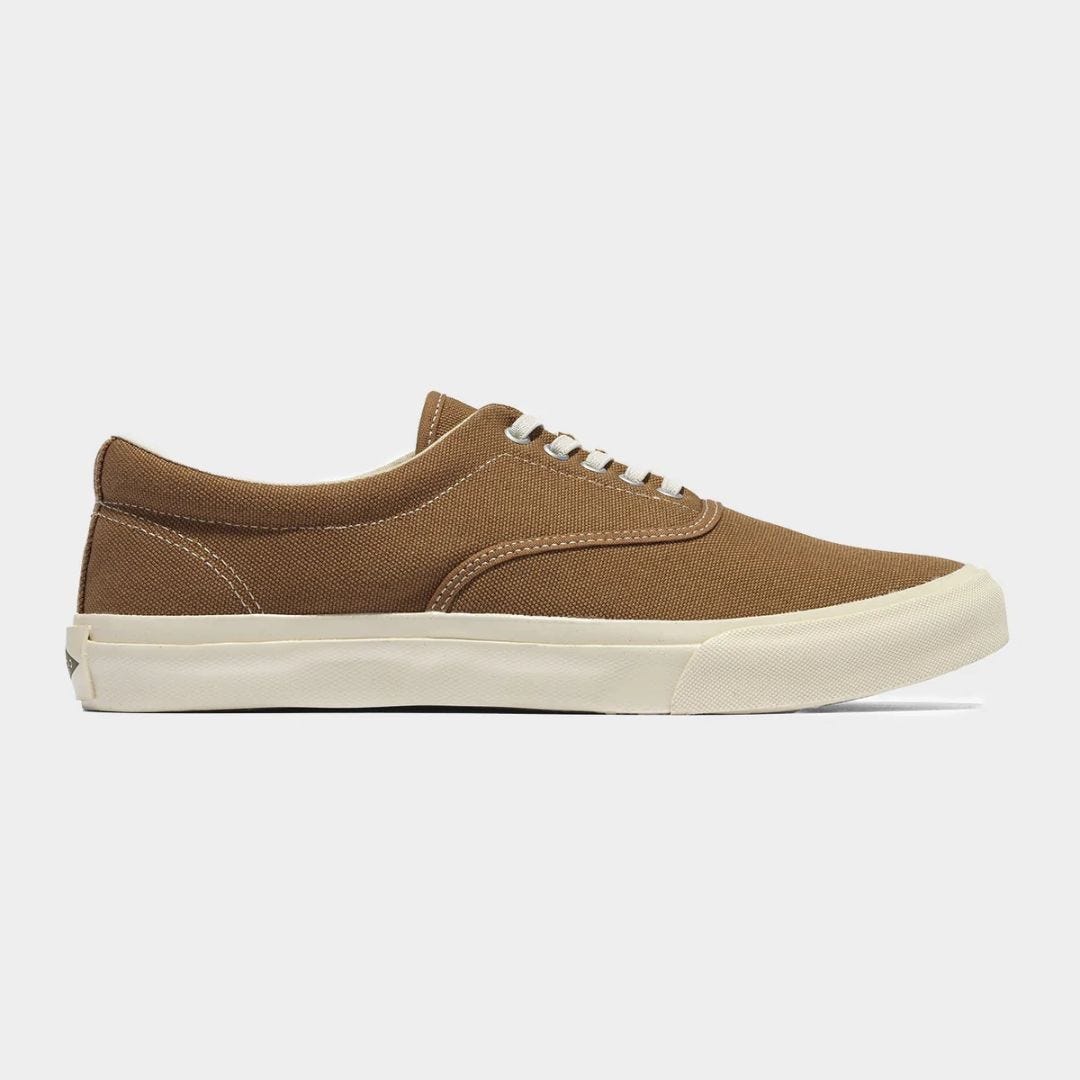 brown canvas sneaker shown from the side against a grey background