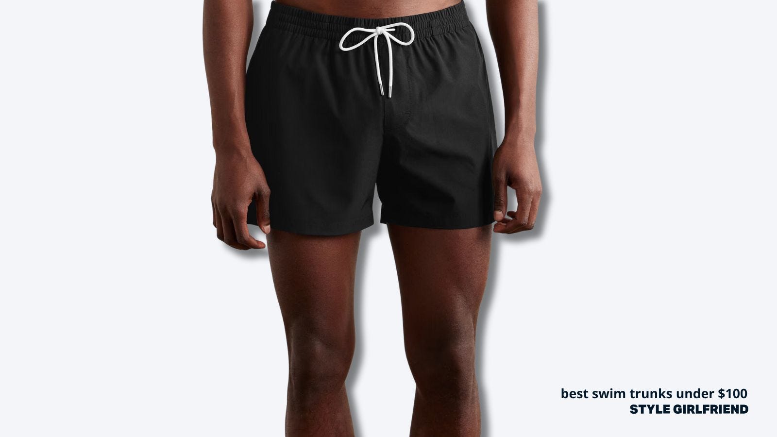 close-up of a slim man in black swim trunks with a white drawstring. text on-screen reads: best swim trunks under $100