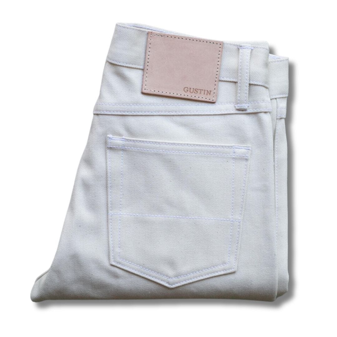 pair of folded white jeans against a blank background