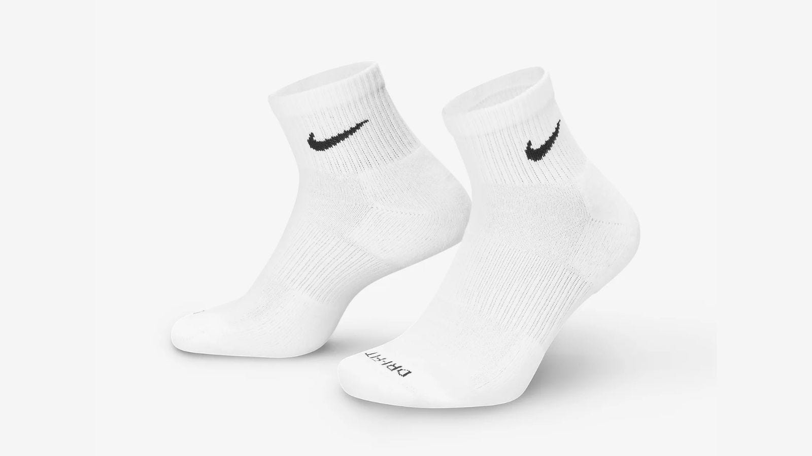 pair of white ankle socks  with black nike swoosh