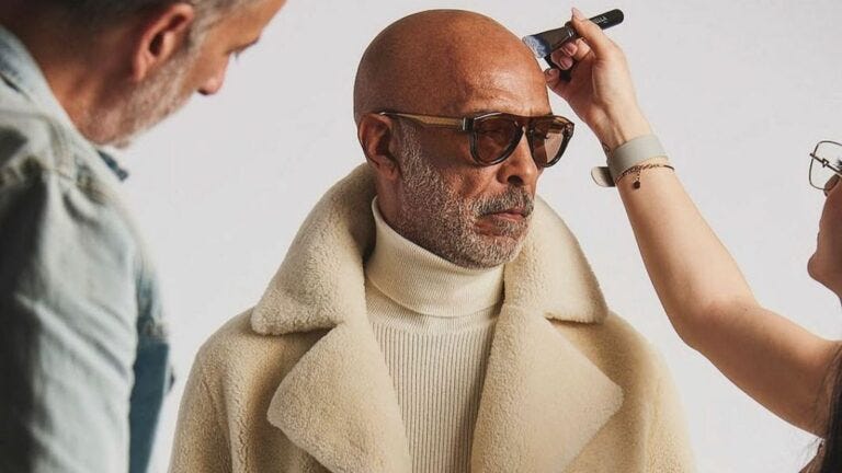 feature image for an article on style for men over fifty, close-up image of an older male model getting touched up at a photo shoot