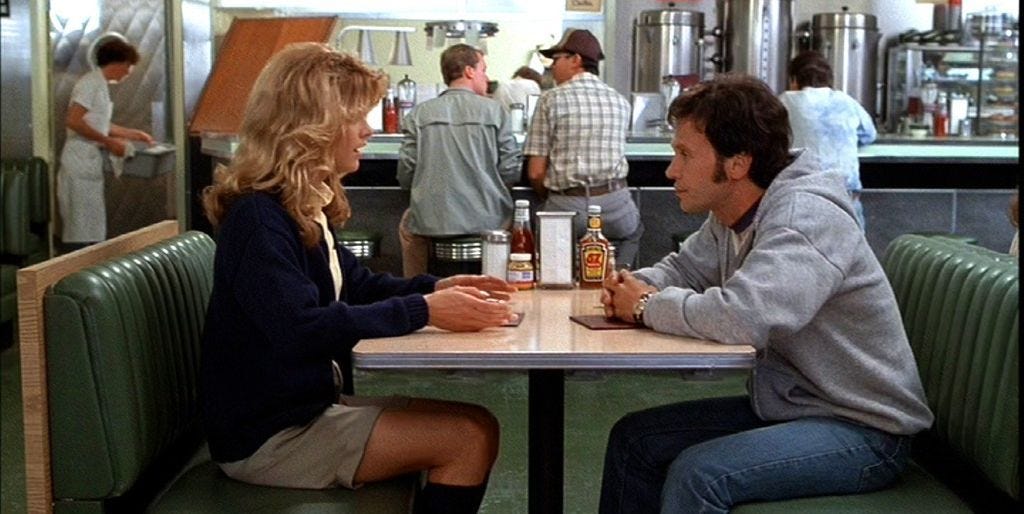 image still from the movie "when harry met sally" where the two characters are sitting facing eachother in a restaurant
