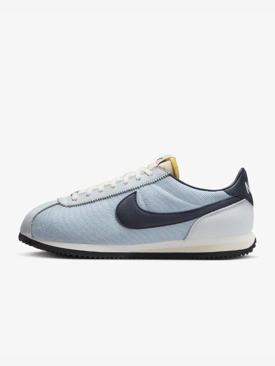 Light blue Nike Cortez sneakers with navy swoosh