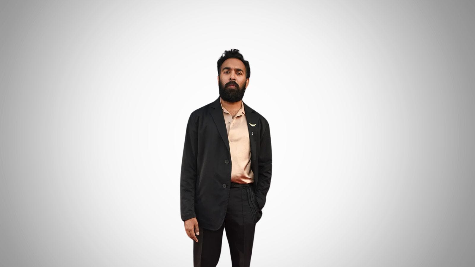 actor Himesh Patel wearing a black suit and tan shirt