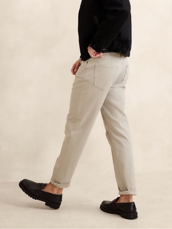 man from the waist down wearing light tan chinos and black loafers