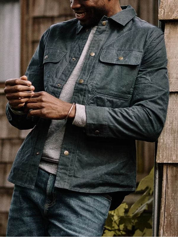 close-up of a man wearing a navy shirt jacket over a grey sweater