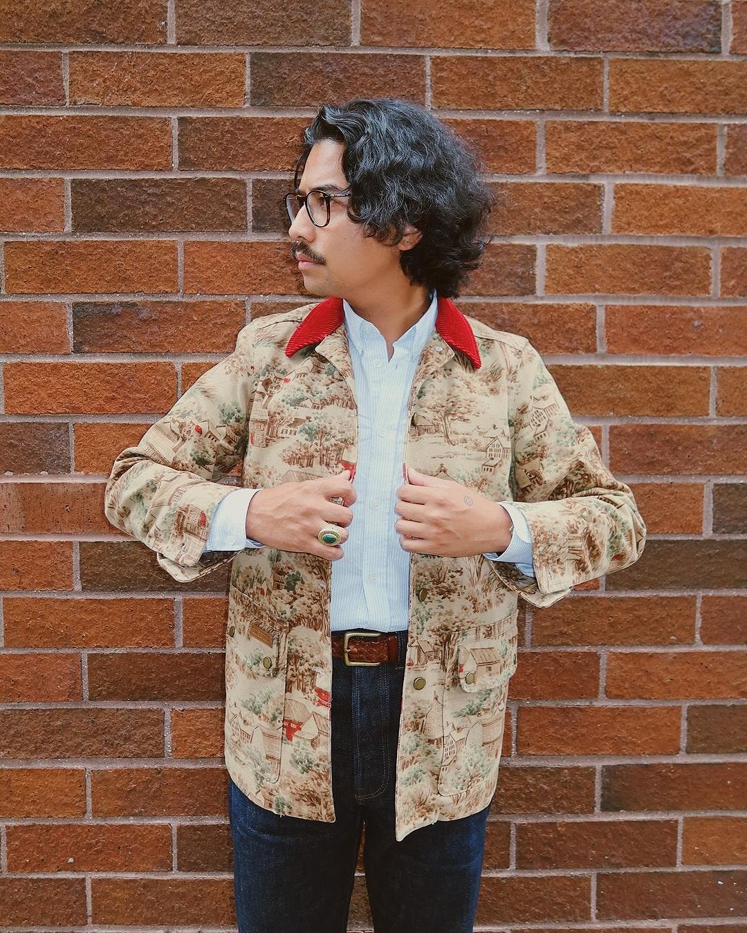 close-up of a man wearing a patterned chore coat with red collar