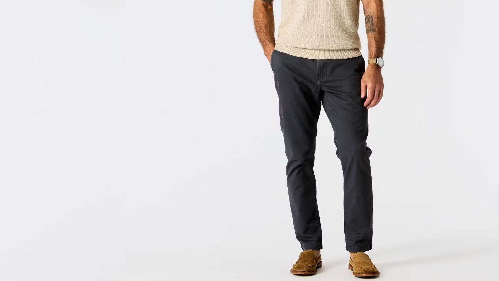 man from the waist down wearing a cream-colored knit polo with navy 365 pants from flint and tinder with suede loafers