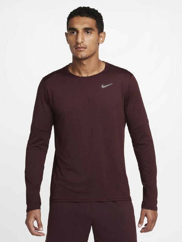 Man wearing long sleeve maroon running shirt from waist up