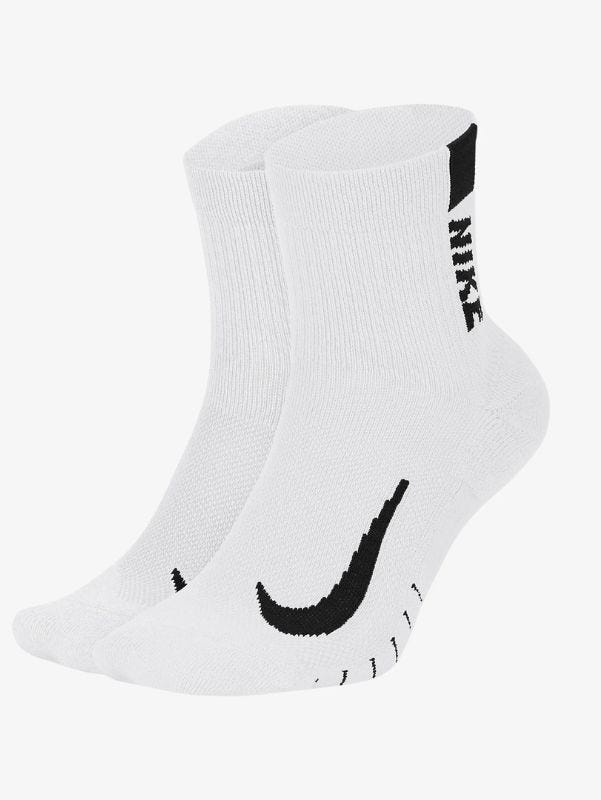 A pair of white Nike running socks with black swooshes on the feet