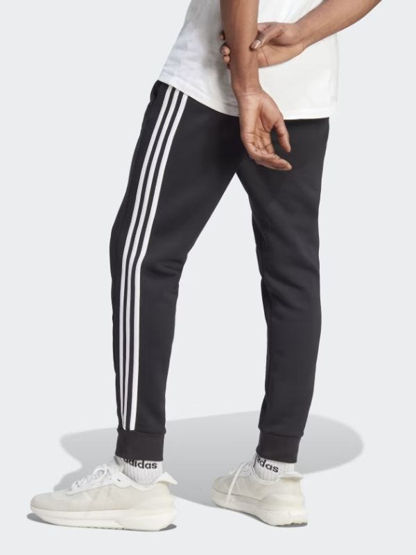 man from behind wearing black track pants and white sneakers