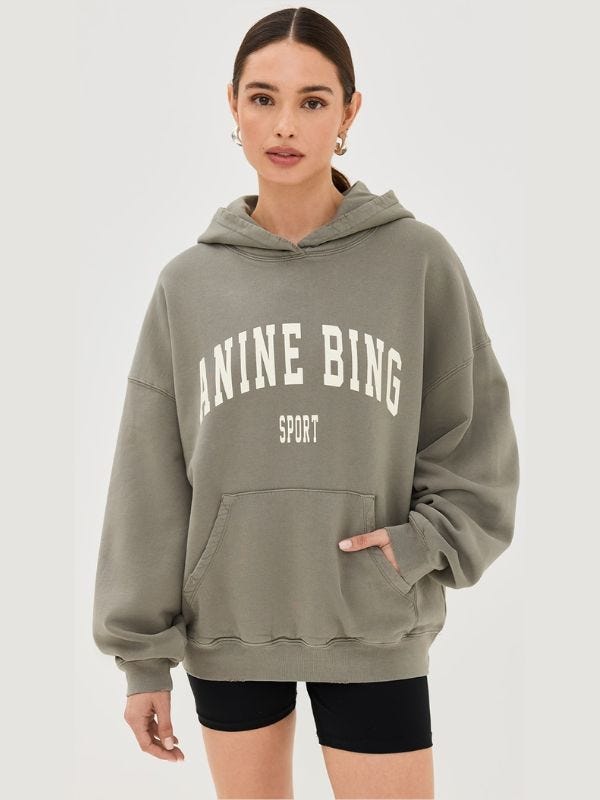 woman wearing an "anine bing sport" hoodie with black biker shorts