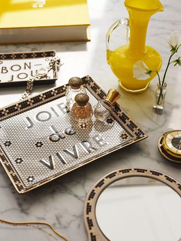 perfume bottles sitting on a decorative tiled tray that reads "joie de vivre"