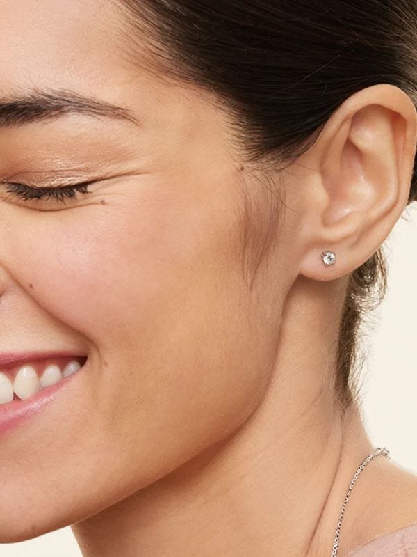 smiling woman wearing diamond stud earrings