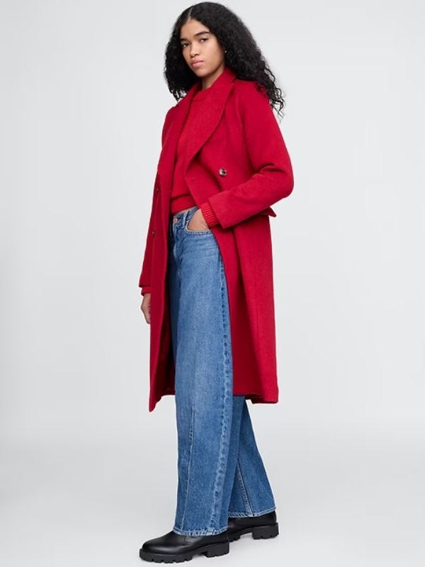 woman wearing a red overcoat with a red sweater and jeans