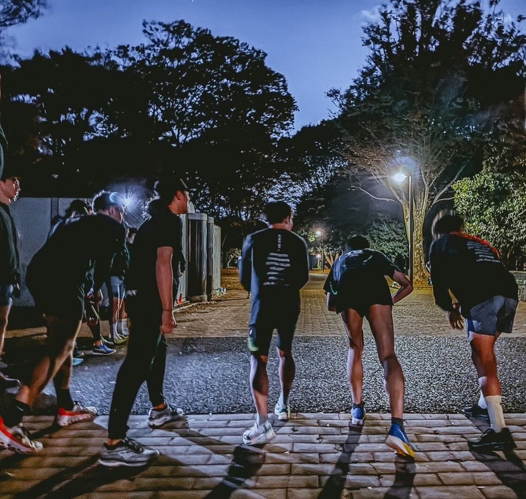 A group of runners lined up to start running in the early morning light