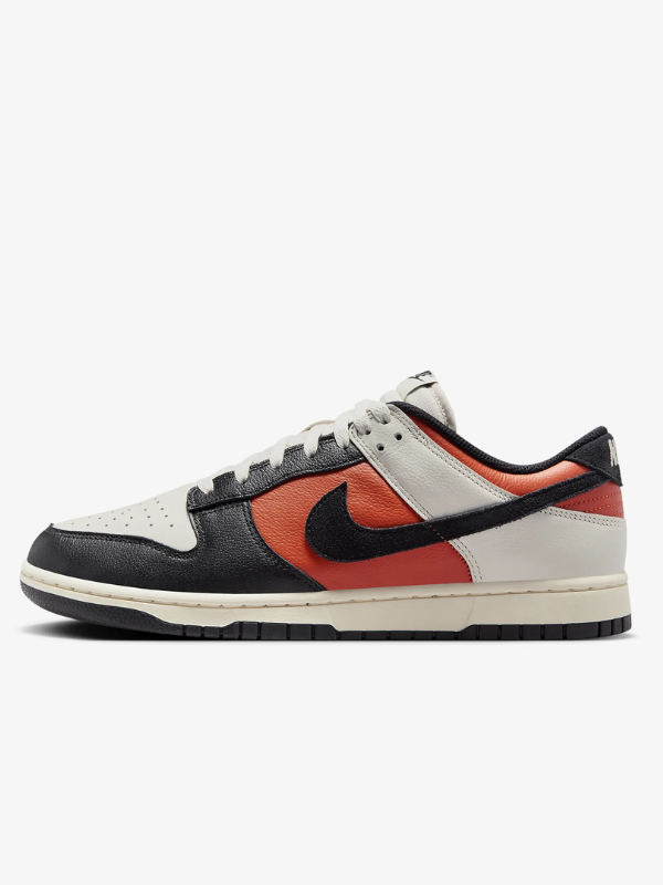 single Nike sneaker in black, orange, and white