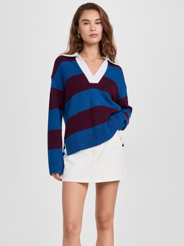 attractive woman wearing a navy and maroon striped sweater with a short white skirt