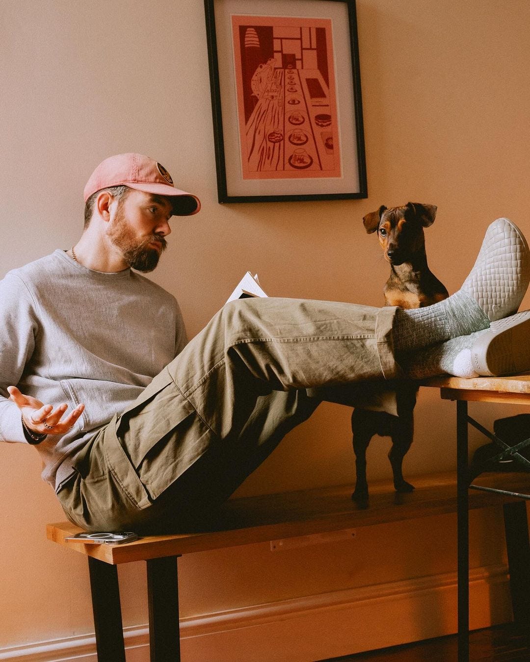 Man puts his feet on the table and looks at a dog