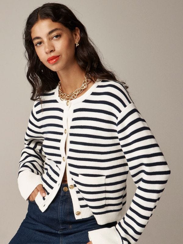 stylish woman wearing a striped sweater jacket with gold buttons