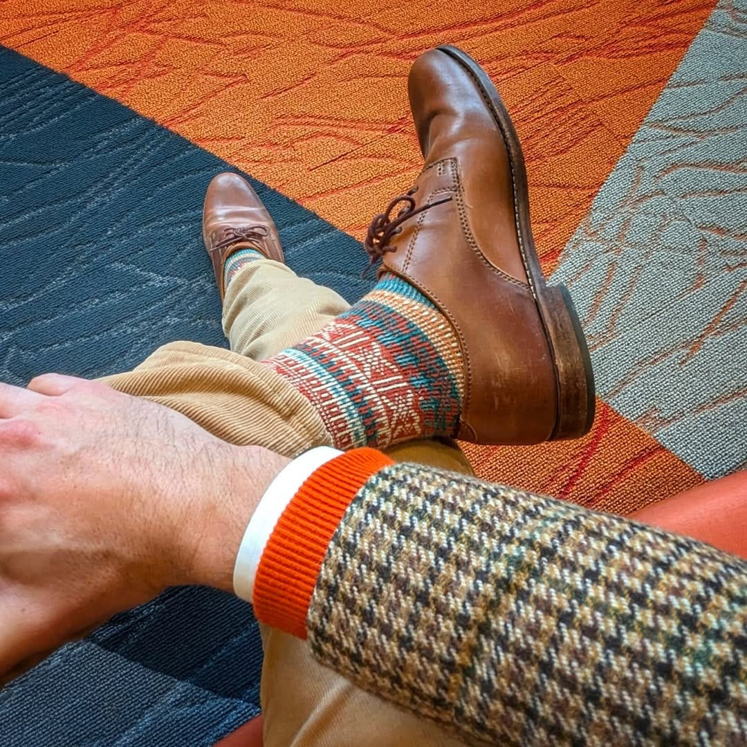 close-up of a man wearing tan corduroy pants, fair isle socks, and brown lace-up shoes