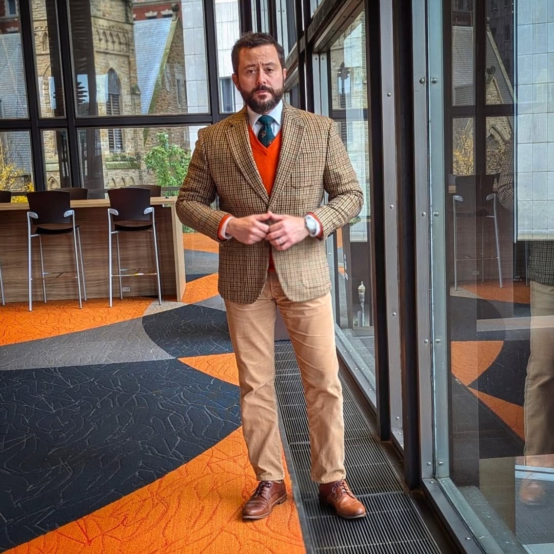 man wearing a patterned blazer and tan corduroy pants