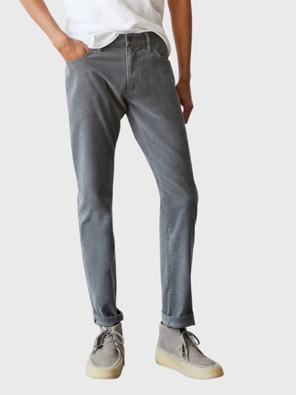 man from the waist down wearing grey 5-pocket corduroy pants with chukka boots