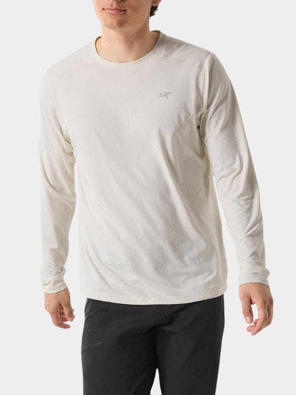 close-up of a man wearing an off-white long-sleeve tee with black pants