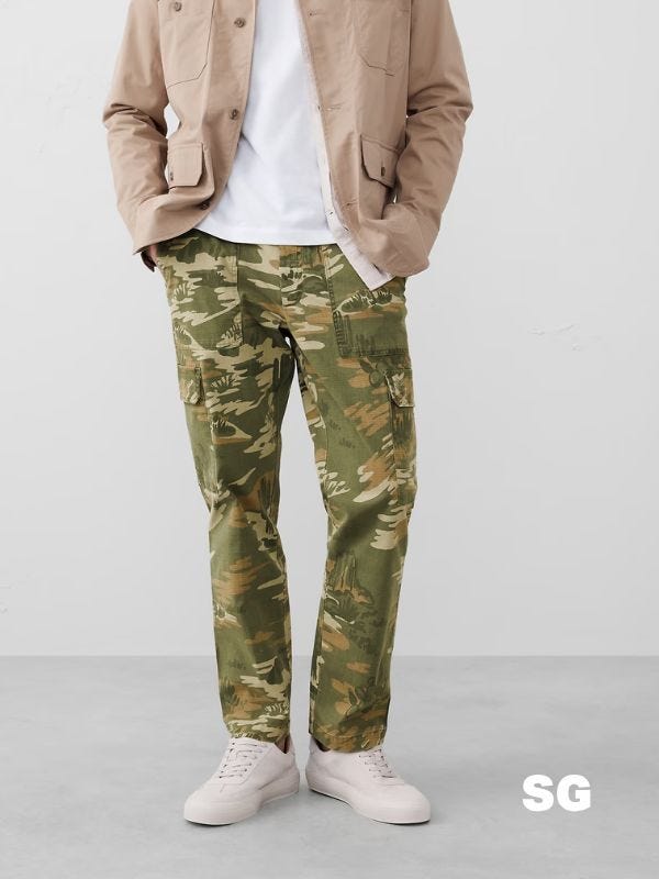 man from the waist down wearing camo cargo pants with white sneakers