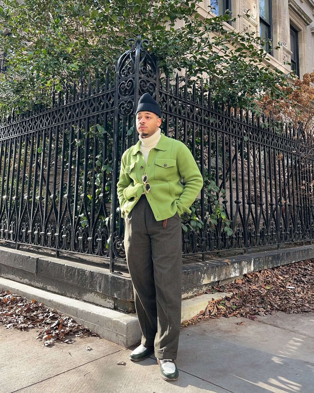 stylish man wearing a green overshirt with a turtleneck and brown trousers