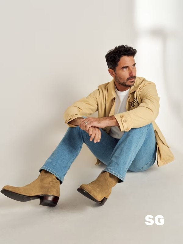 stylish man wearing suede cowboy boots with blue jeans and a tan button-down shirt