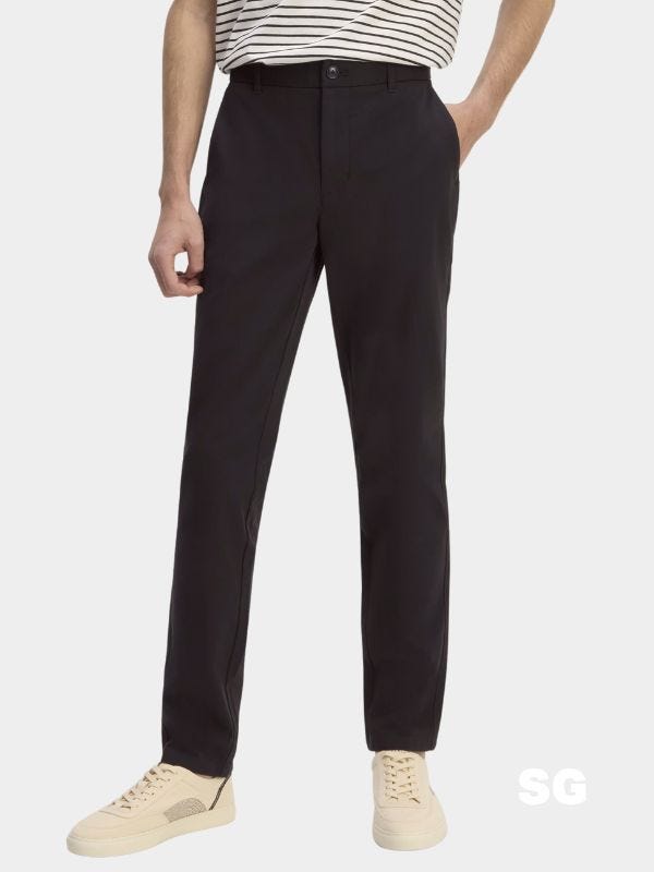 man from the waist down wearing black chinos and off-white sneakers