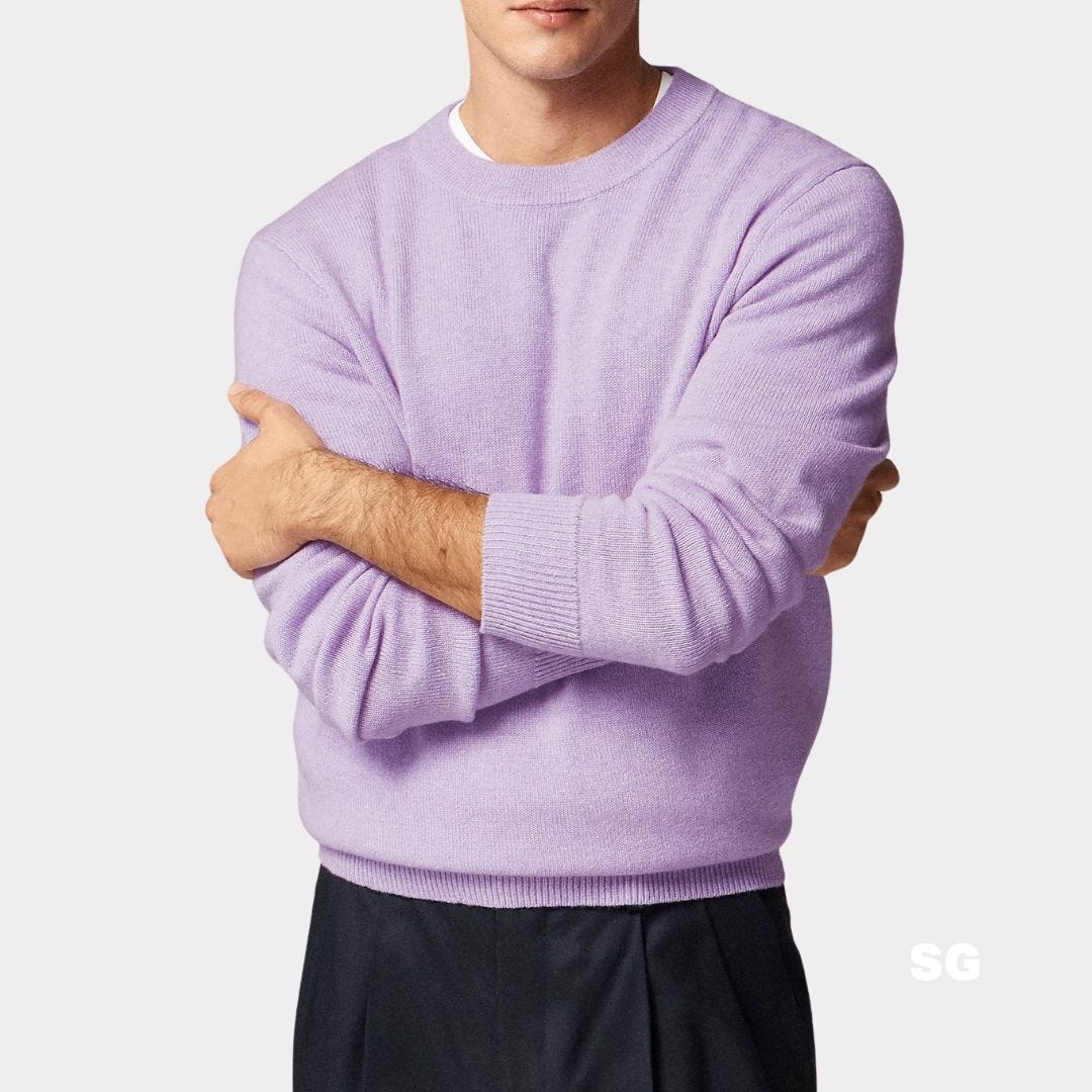 close-up of a man wearing a crewneck lavender sweater with dark pants