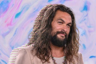 actor Jason Momoa in front of a blue wavy background