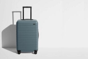 blueish-grey suitcase against a grey background