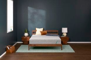 tuft and needle mattress on a wooden bedframe in a bedroom with two nightstands, all on an area rug