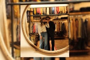 image of couple taking a selfie with a camera in the mirror of a clothing store